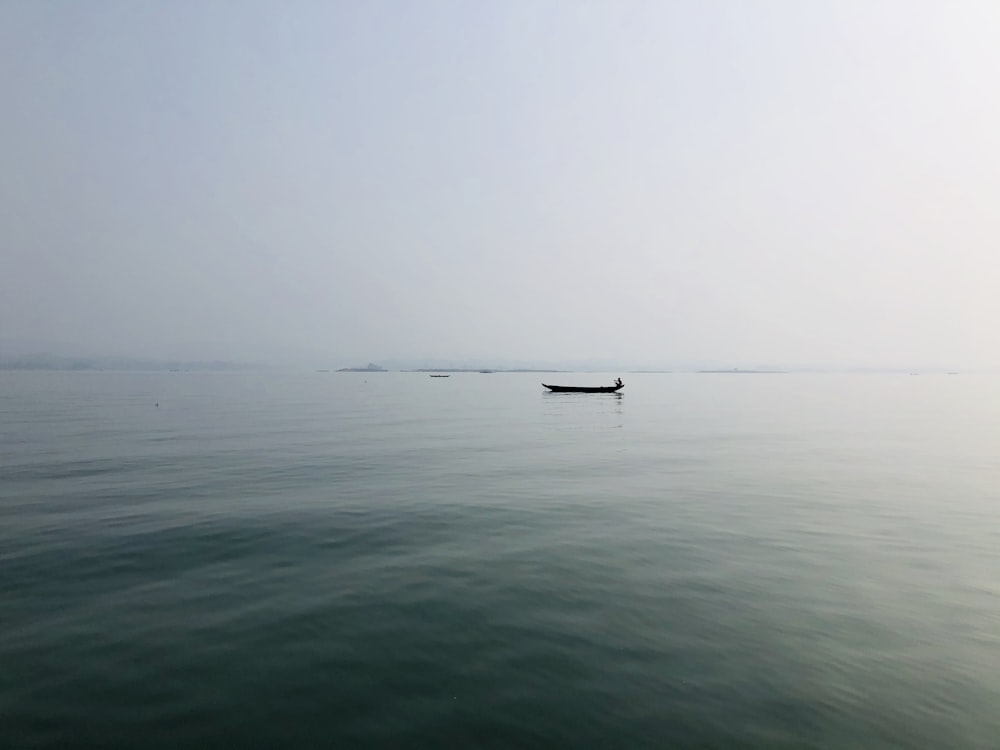 boat on sea under foggy weather