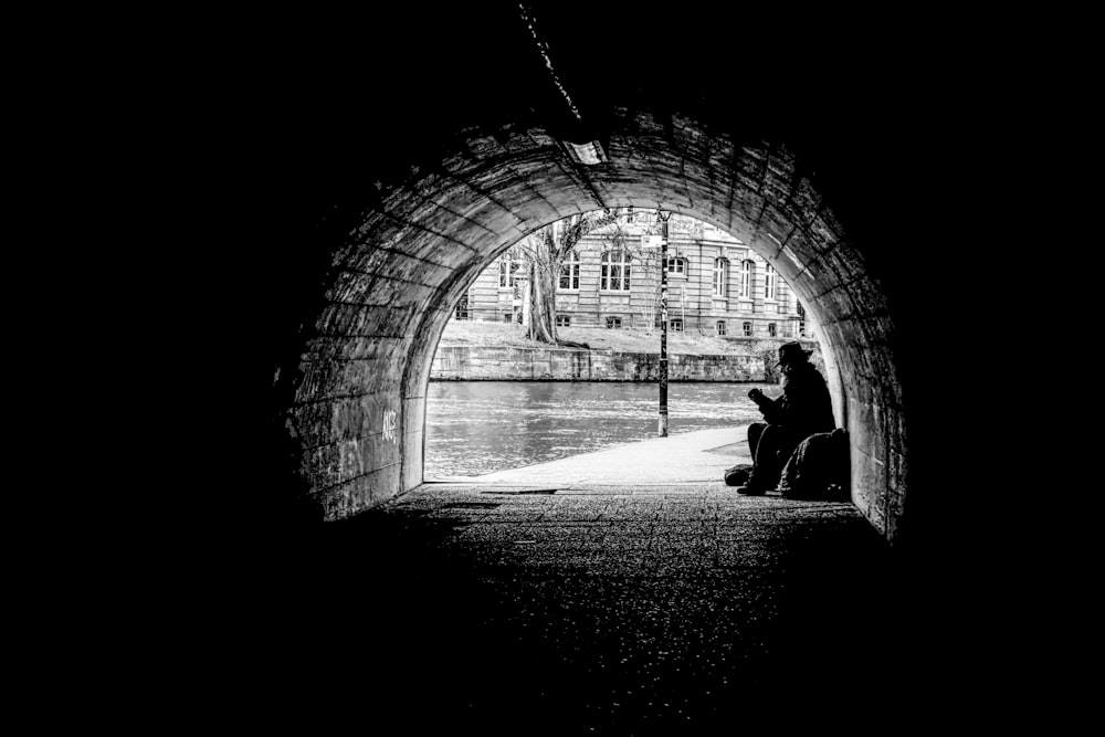 silhouette of person sitting on tunnel