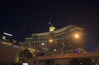 A cinematic view of a luxury hotel facade illuminated against a charcoal night sky.