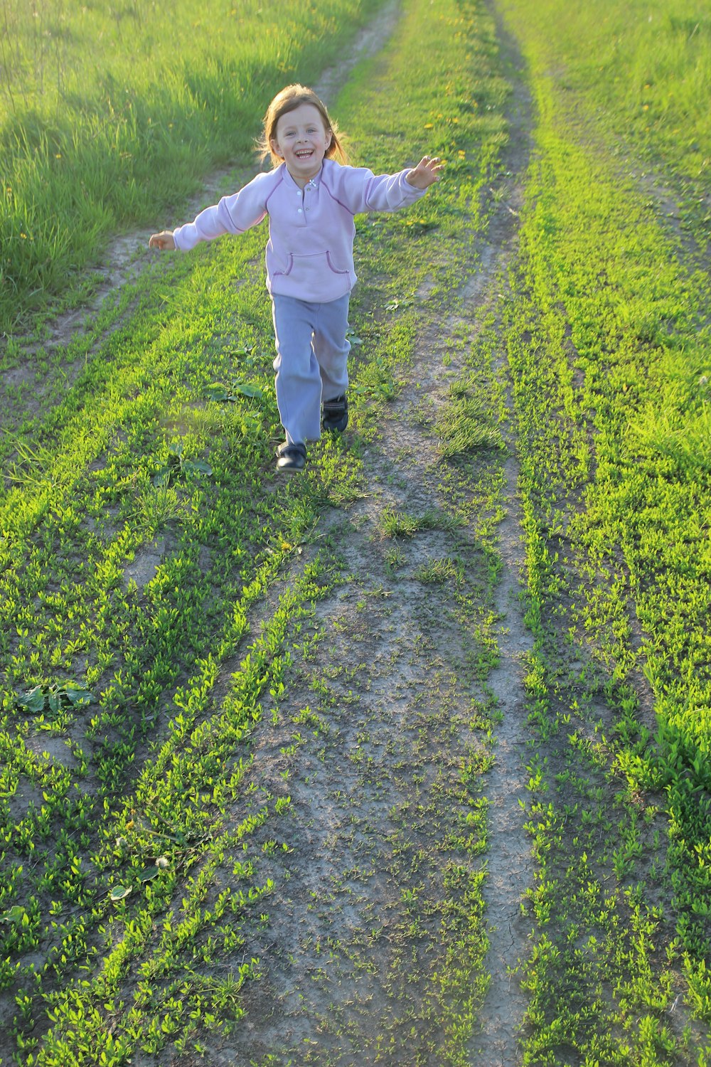 person in white pants walking on green grass field during daytime