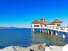 white and brown wooden house on sea during daytime