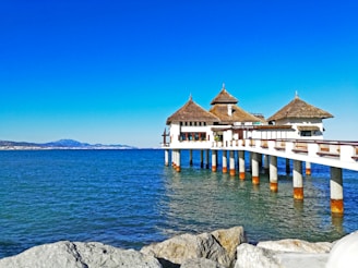 white and brown wooden house on sea during daytime