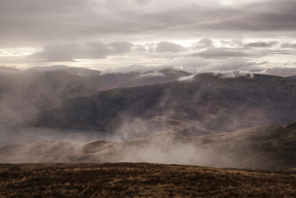 brown and green mountains under white clouds during daytime