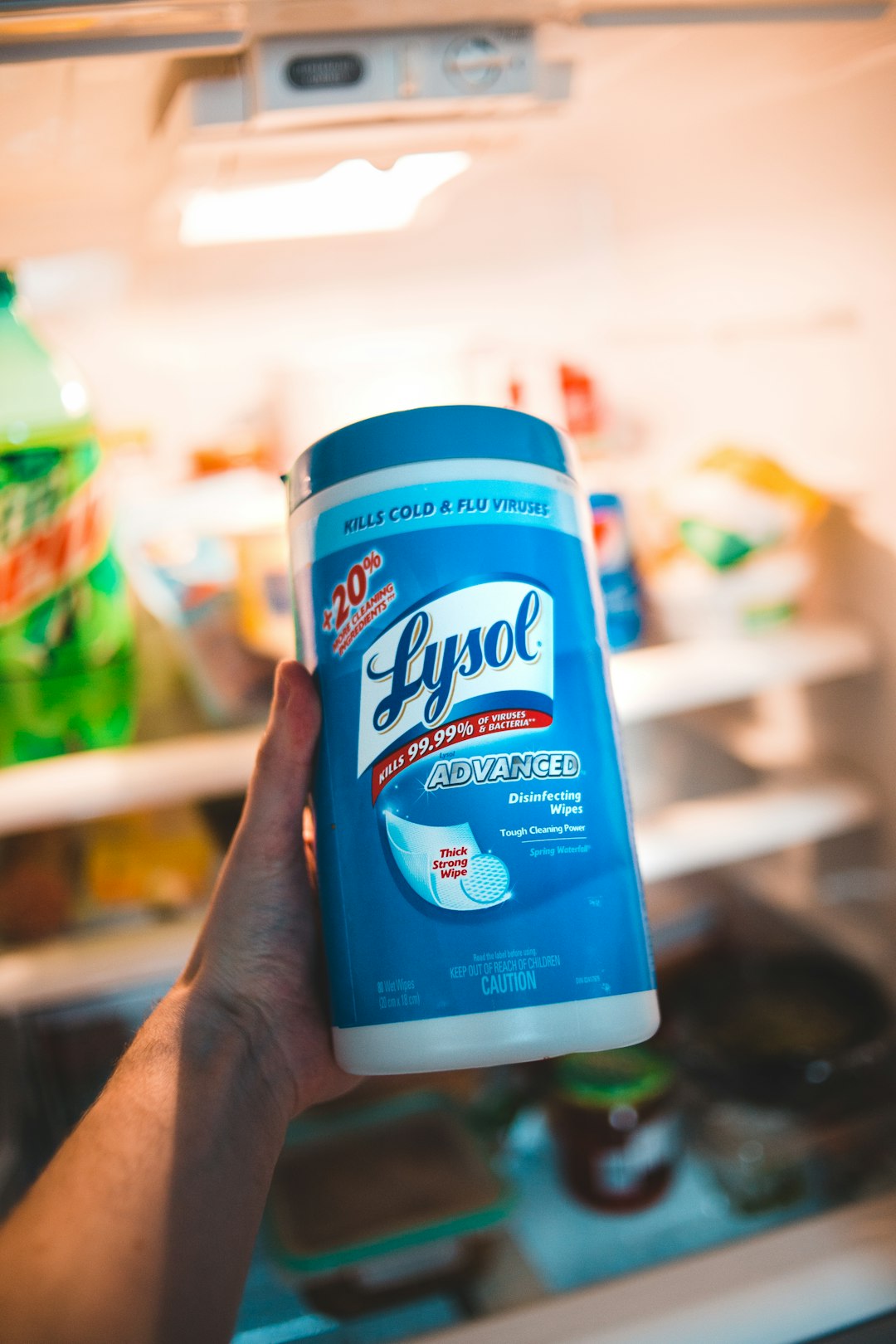 person holding blue and white lysol disinfecting wipes