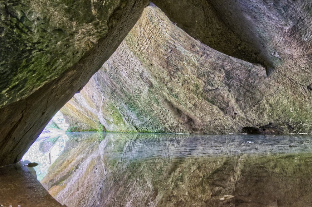 body of water between gray rock formation during daytime