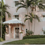 A stylish townhouse with coral accents and lush landscaping in a friendly neighborhood