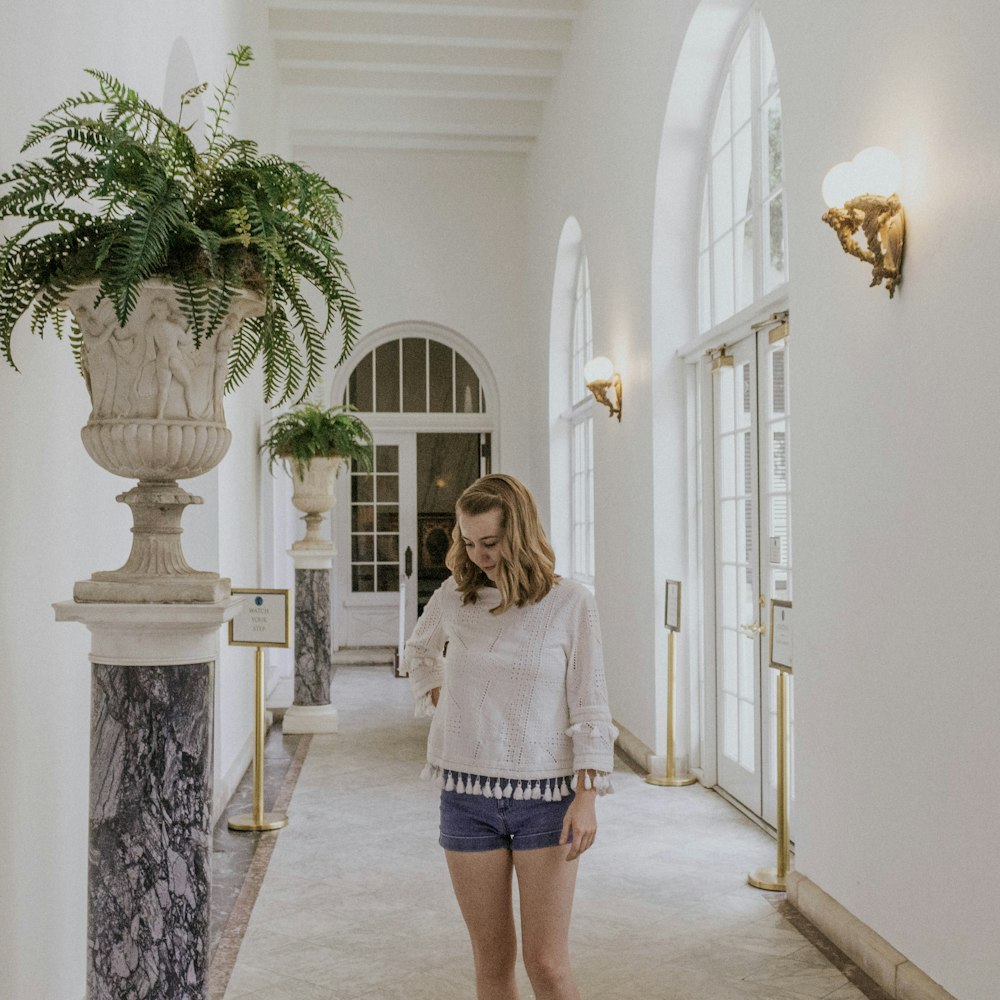 woman in white sweater standing on hallway