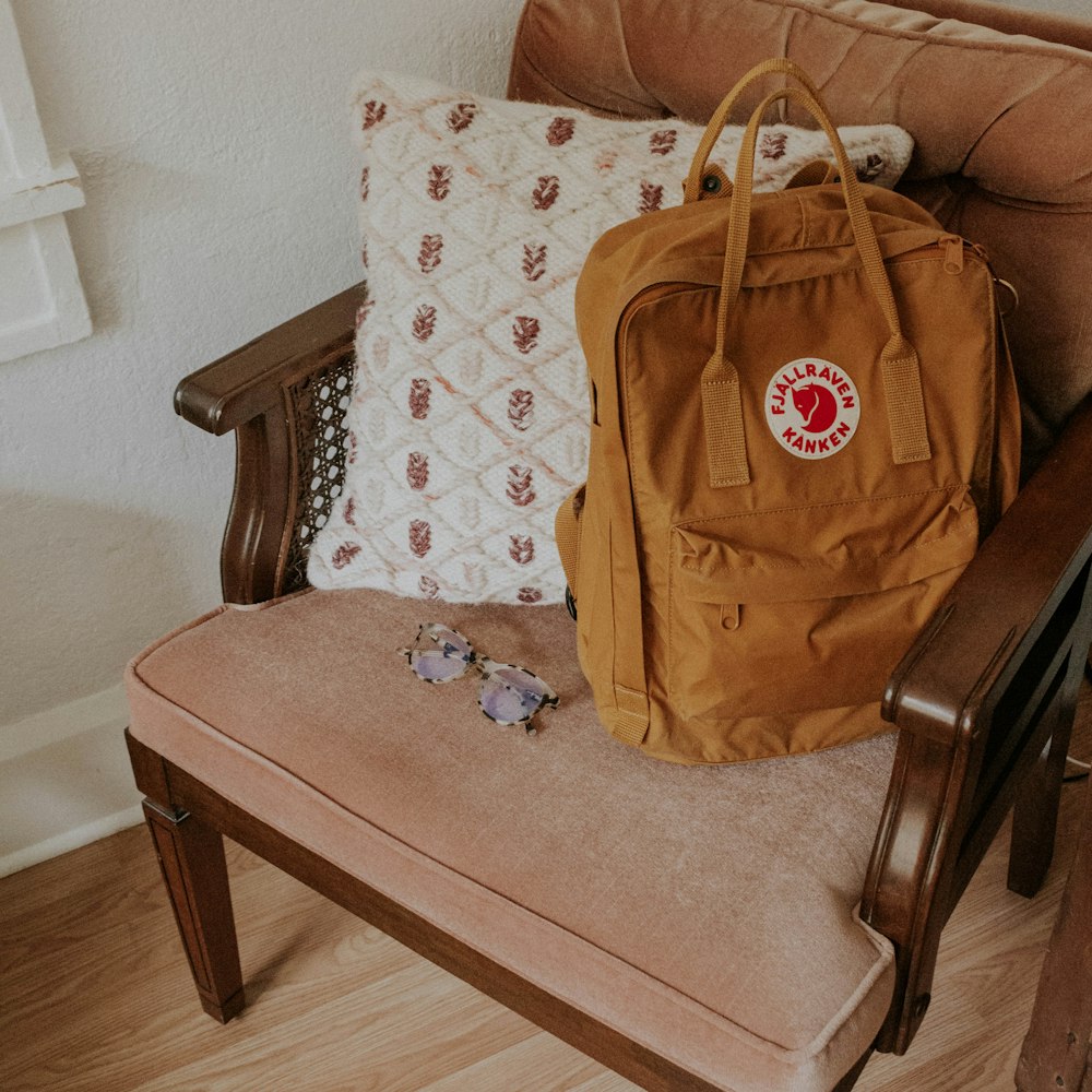 brown leather tote bag on brown wooden armchair