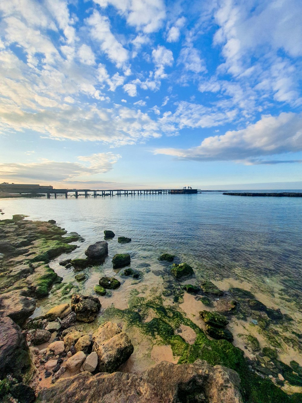 brown wooden dock on sea under blue sky during daytime