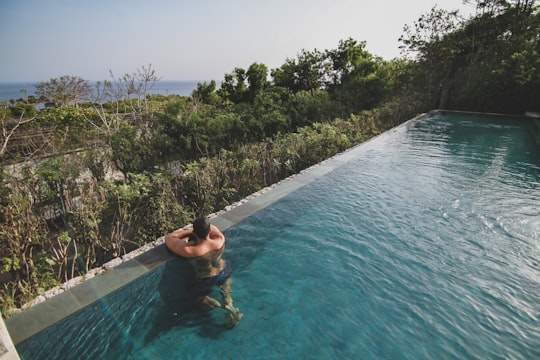 man in swimming pool during daytime in Uluwatu Indonesia