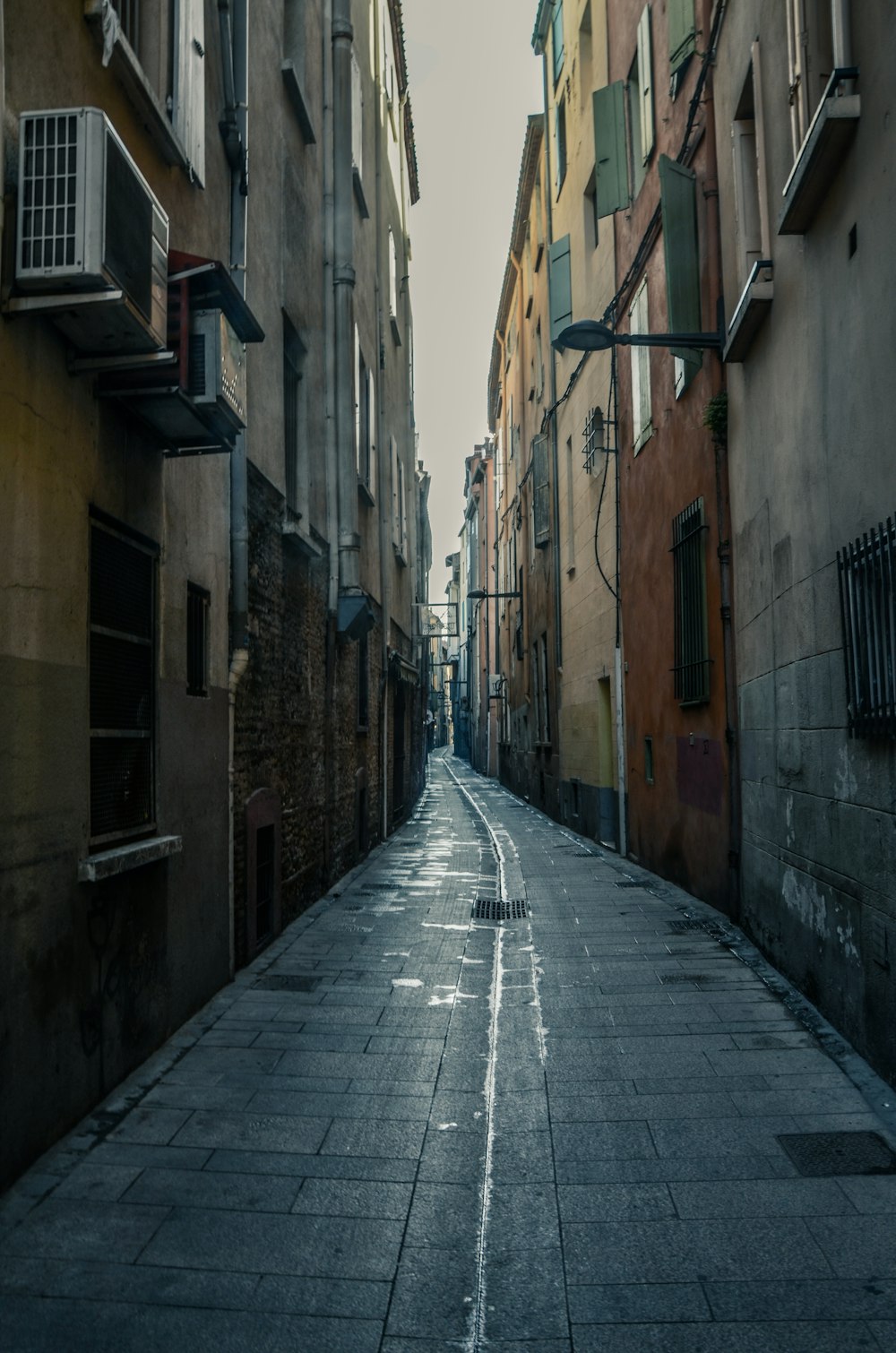 Calle vacía entre edificios de hormigón marrón durante el día