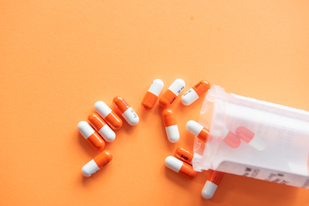 Prescription drugs on an orange background with a pill bottle. Orange pills. 
