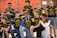 A group of young athletes wearing blue and yellow jerseys are gathered in a gym with climbing walls in the background. The jerseys have numbers and the words 'West Hernando' on them. Some are standing, while others are kneeling, showing camaraderie and team spirit.