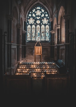 A serene chapel with stained glass windows glowing in the sunset.