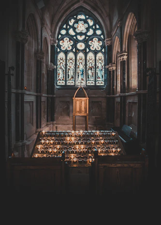 A warm, inviting chapel room with sunlight streaming through stained glass windows.