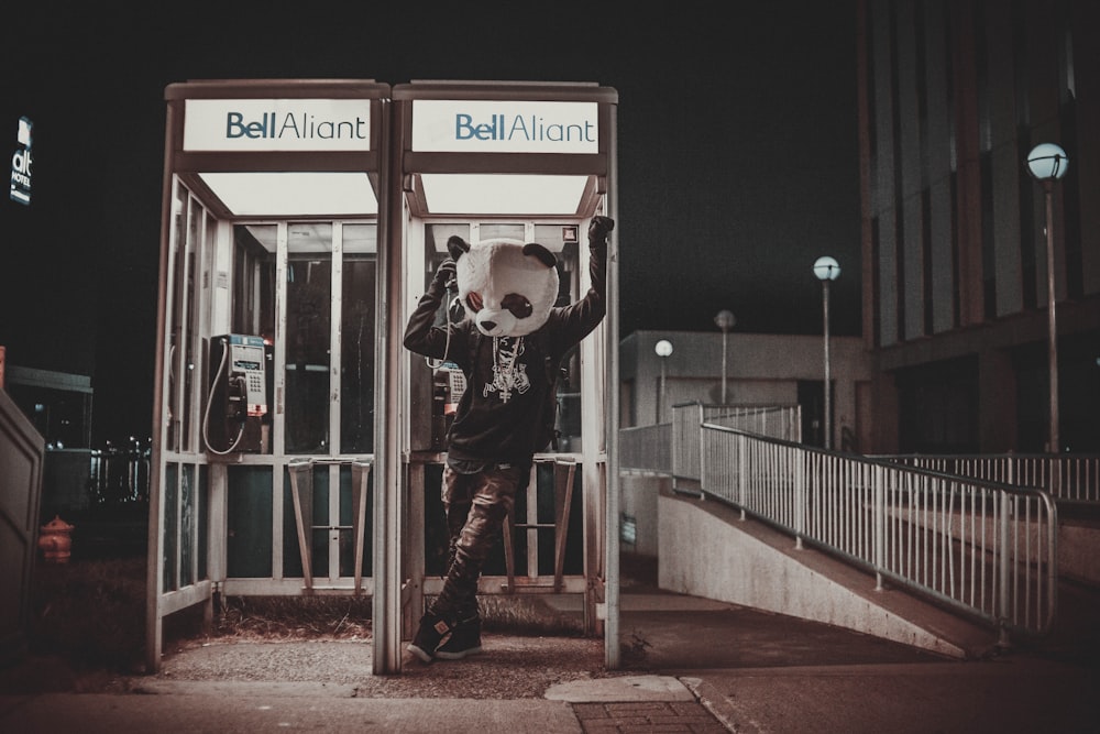 man in black and white shirt playing guitar on street during night time