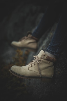 person wearing blue denim jeans and brown leather lace up shoes