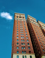 Photograph of the school’s historic building facade under a clear sky.