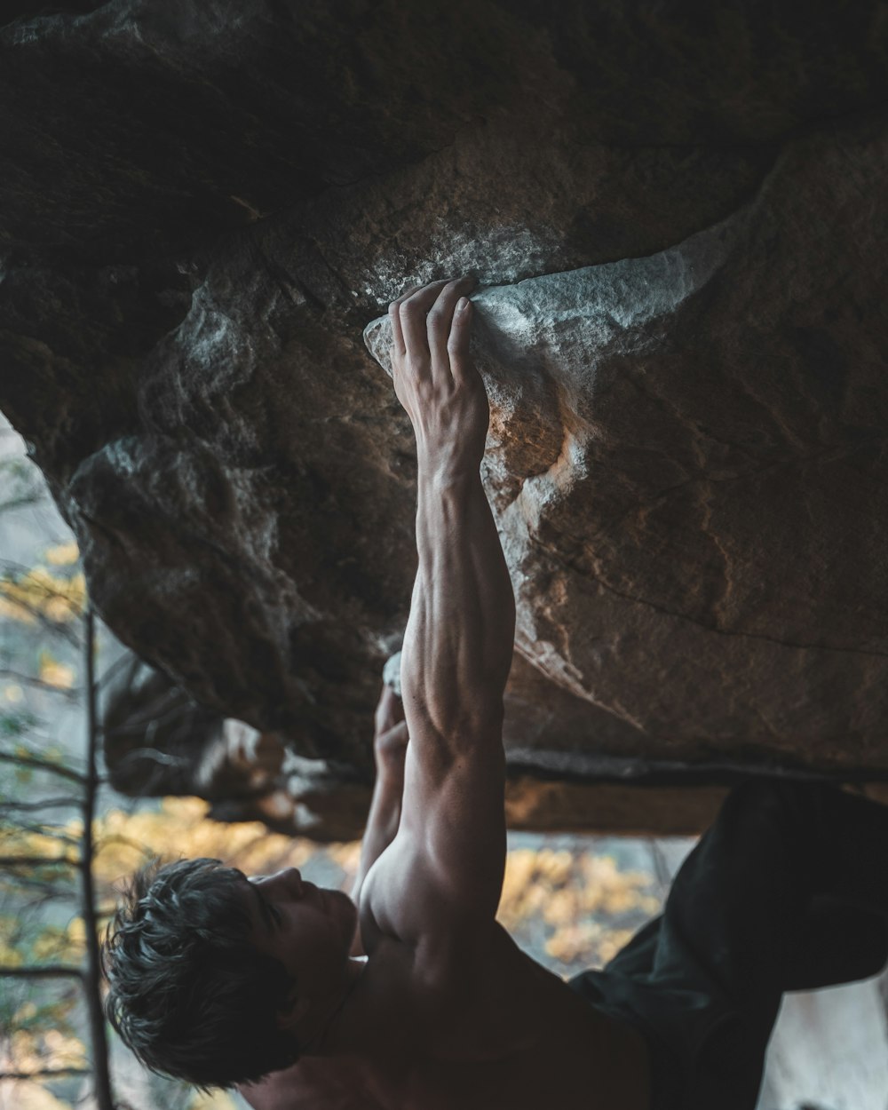 person in black pants sitting on rock