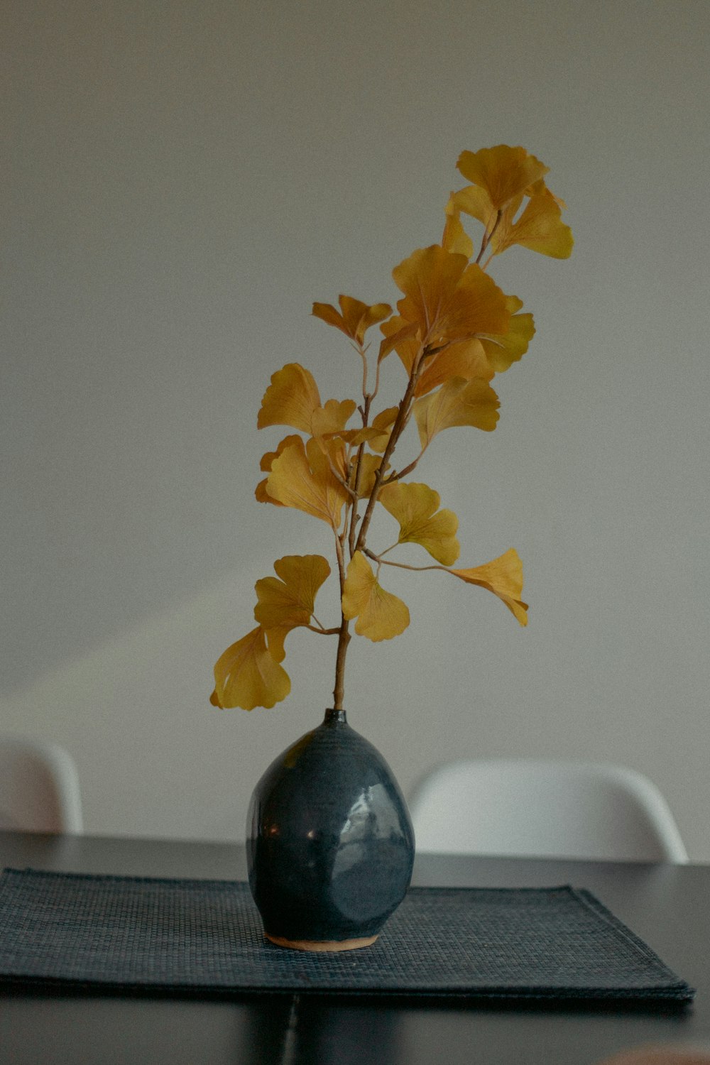 feuilles jaunes sur vase en verre bleu