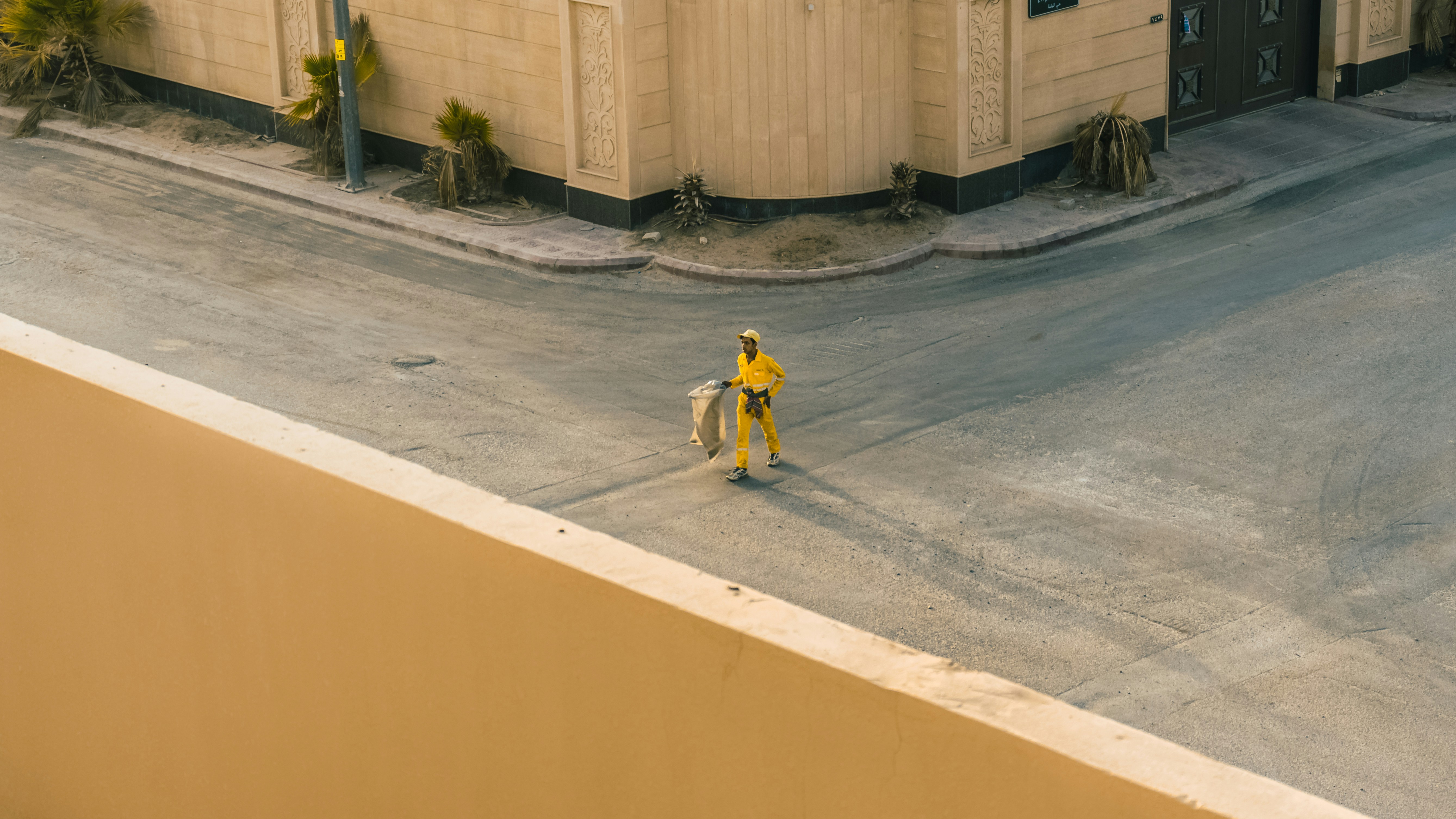 man in yellow shirt riding bicycle on gray concrete road during daytime saudi arabia teams background