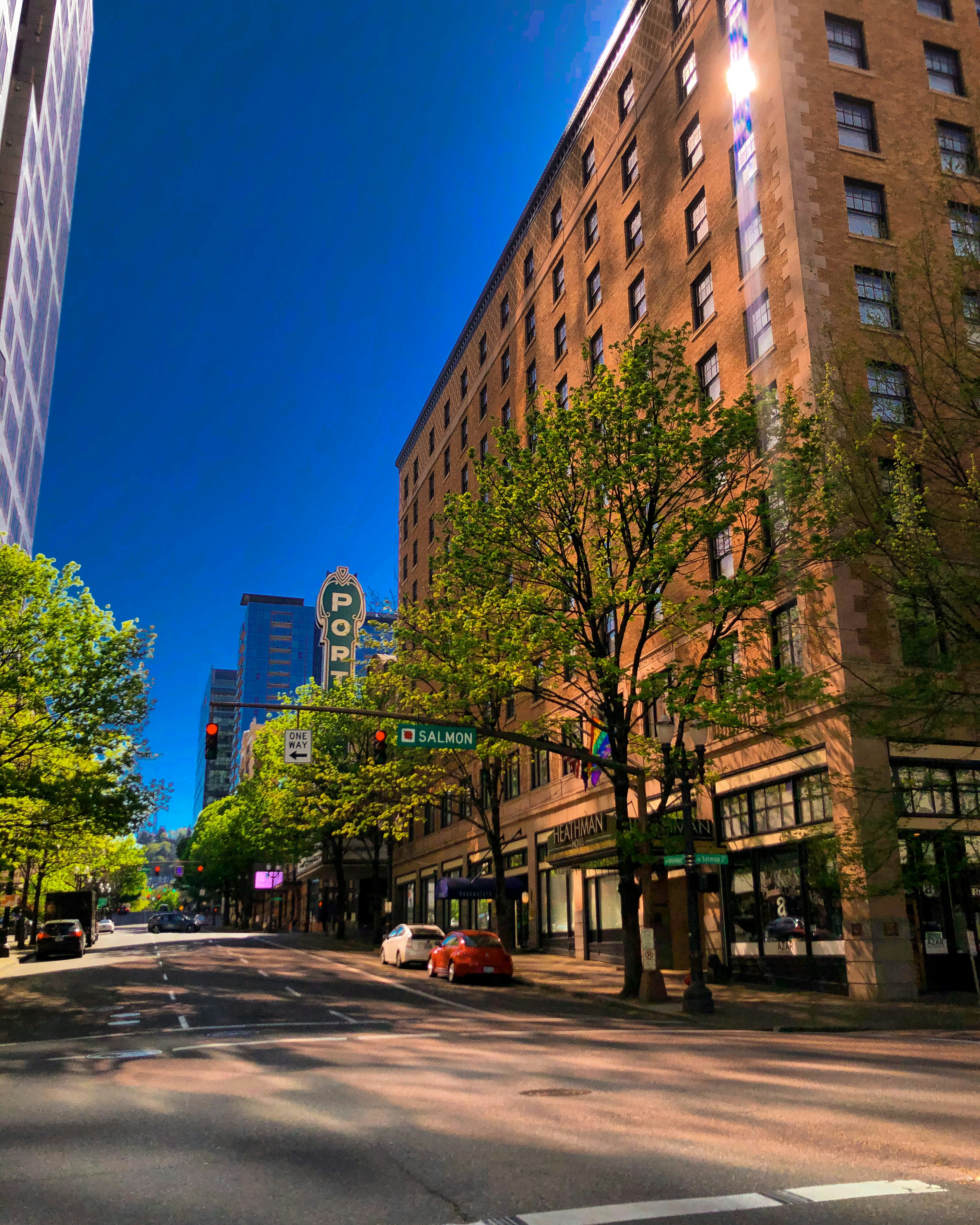 cars parked on side of the road near high rise buildings during daytime
