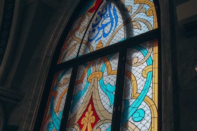 Sunlight streaming through stained glass windows inside Masjid Al Falaq.