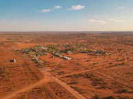 A wide shot of a rural village in Tharparkar with the R.O. plant visible, surrounded by desert landscape.