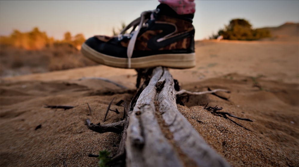 black and white nike sneakers on brown sand