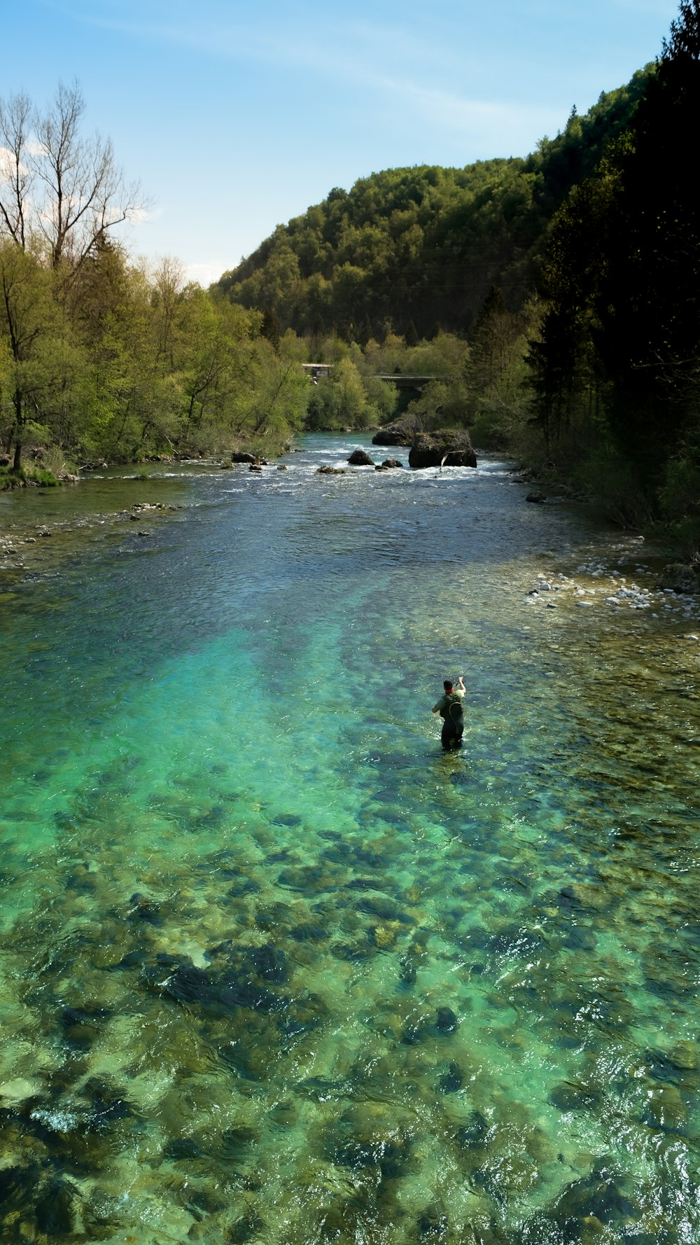 person in black jacket standing on river during daytime