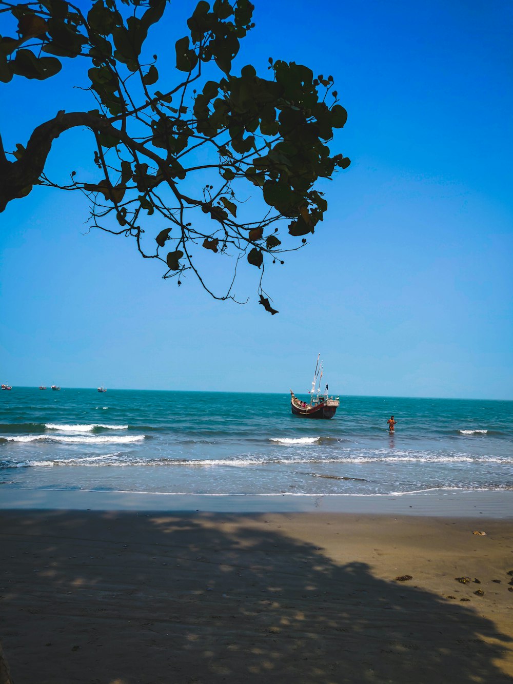 a boat in the ocean near a beach