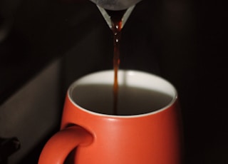 red ceramic mug with coffee