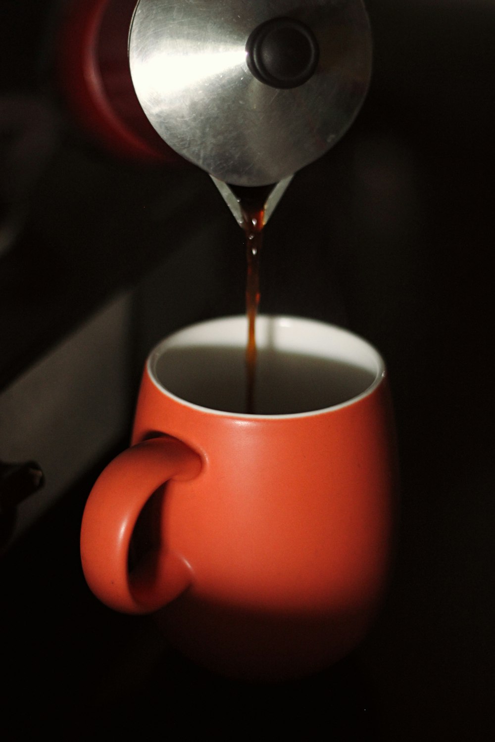 red ceramic mug with coffee