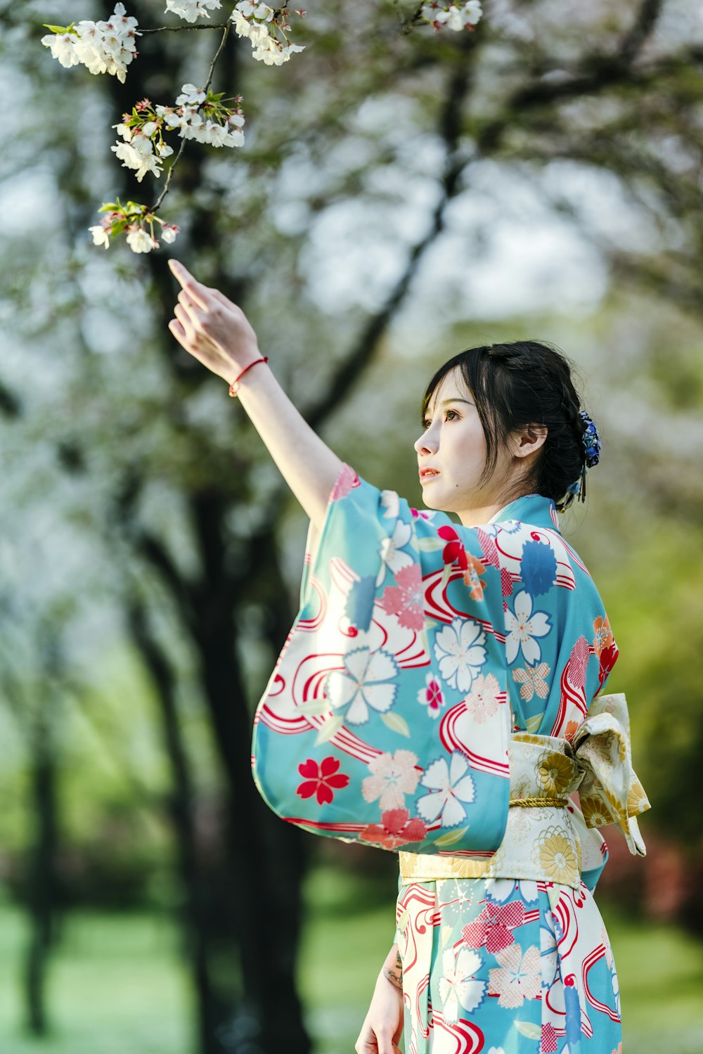 woman in red and white floral kimono holding yellow flower