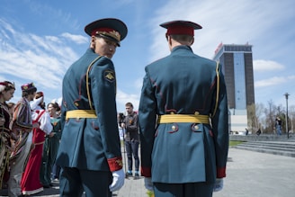 3 men in green coat standing on white floor during daytime