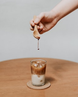 person holding brown wooden spoon