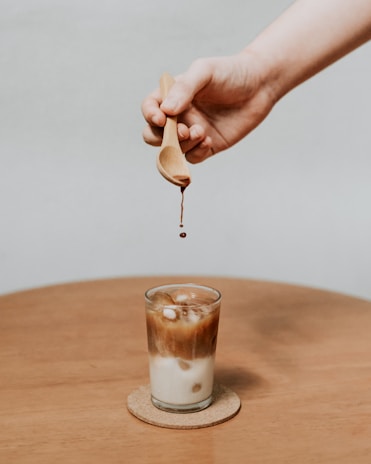 person holding brown wooden spoon