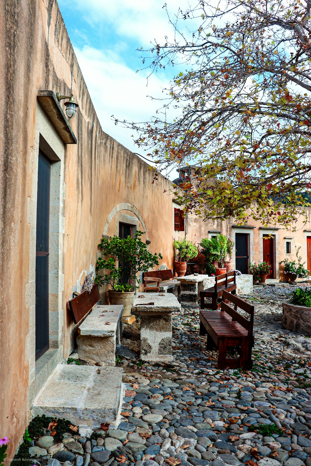 brown wooden table and chairs near brown concrete building during daytime