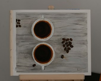 Two cups of coffee are positioned on a wooden surface, with coffee beans scattered artistically around them. The composition has a rustic feel, enhanced by the texture of the wooden background and the rich, dark color of the coffee.