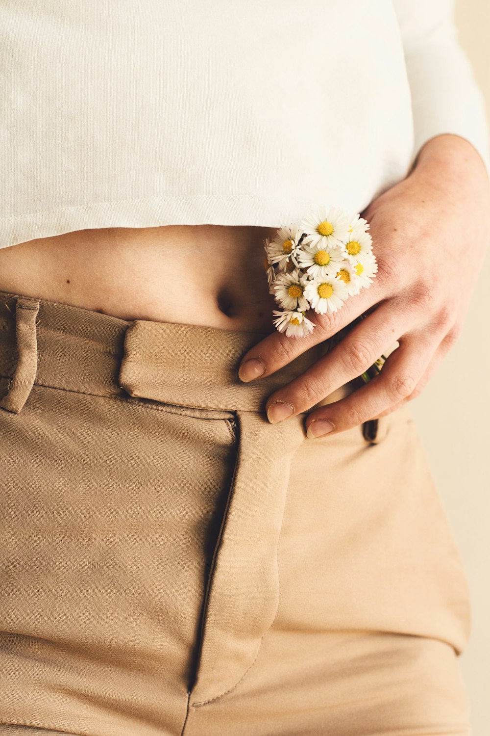 person wearing brown pants with white and yellow flower on his her lap