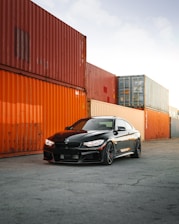 black bmw m 3 coupe parked beside orange wall