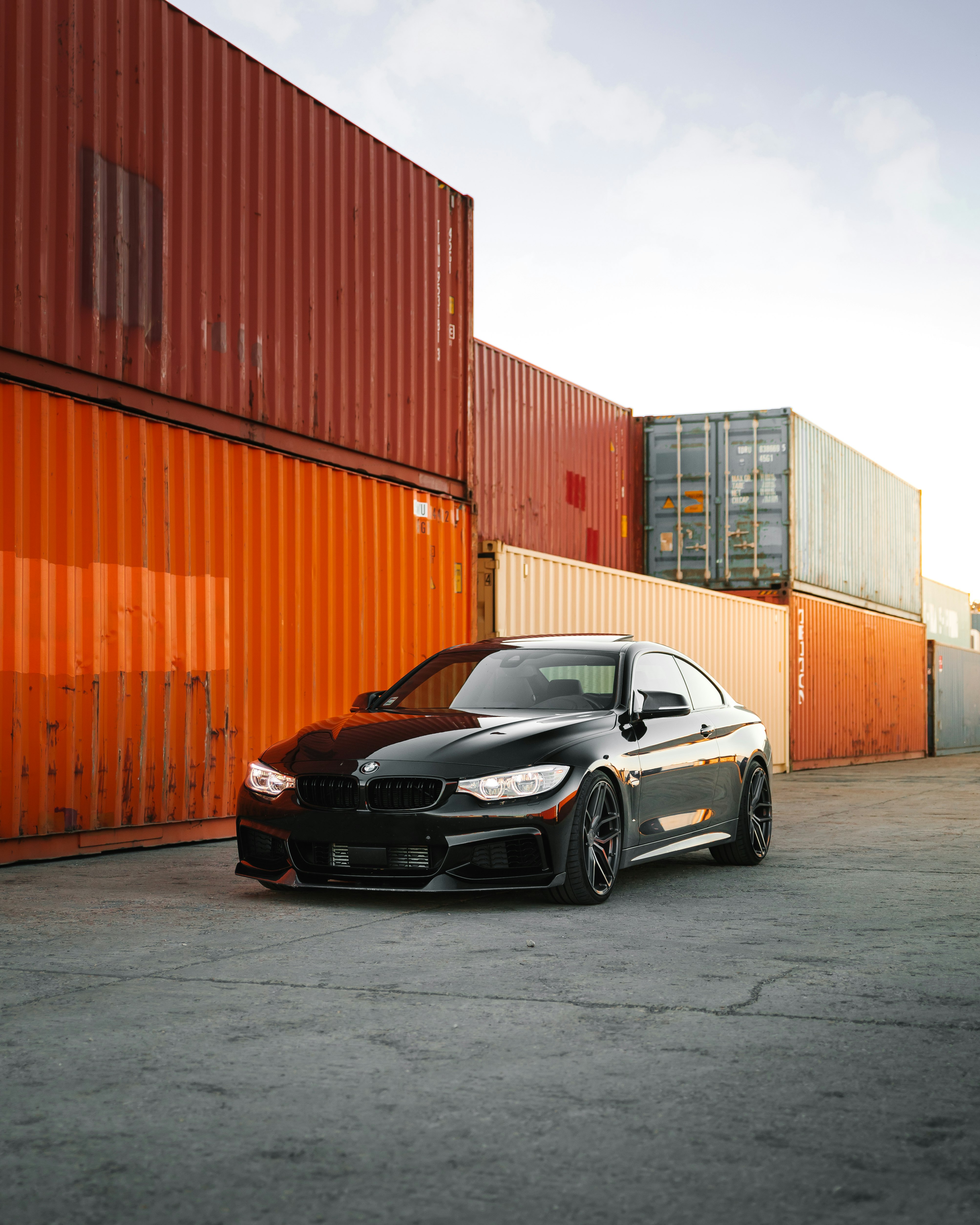 black bmw m 3 coupe parked beside orange wall