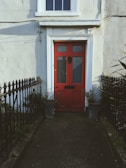 A sturdy front door painted deep red, welcoming and bold.