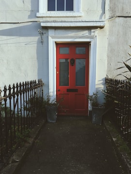Bright red front door with decorative wreath and polished brass knocker.