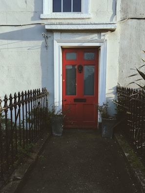 A sturdy front door painted deep red, welcoming and bold.