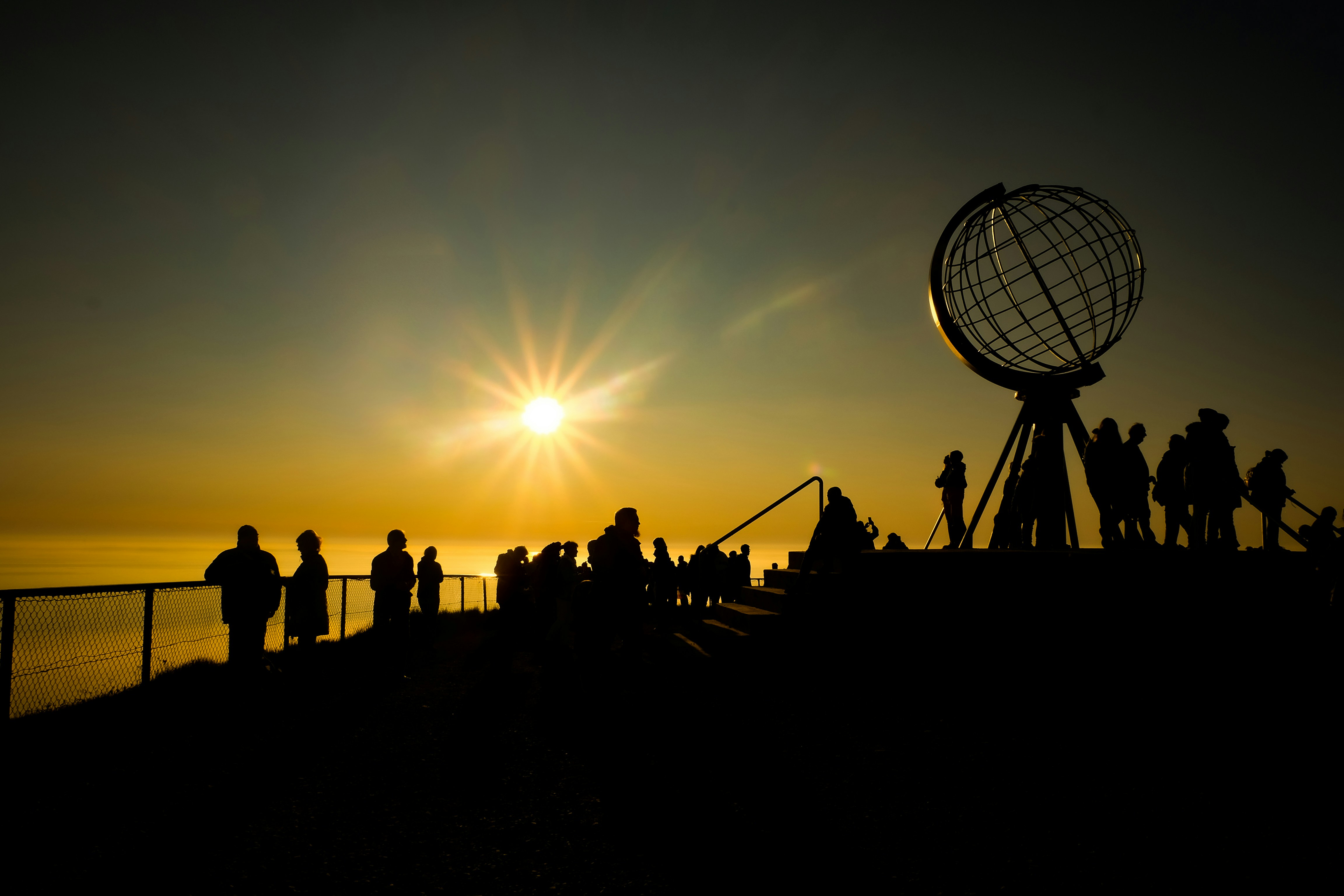 silhouette de personnes debout sur la plage pendant le coucher du soleil