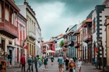people walking on street between buildings during daytime