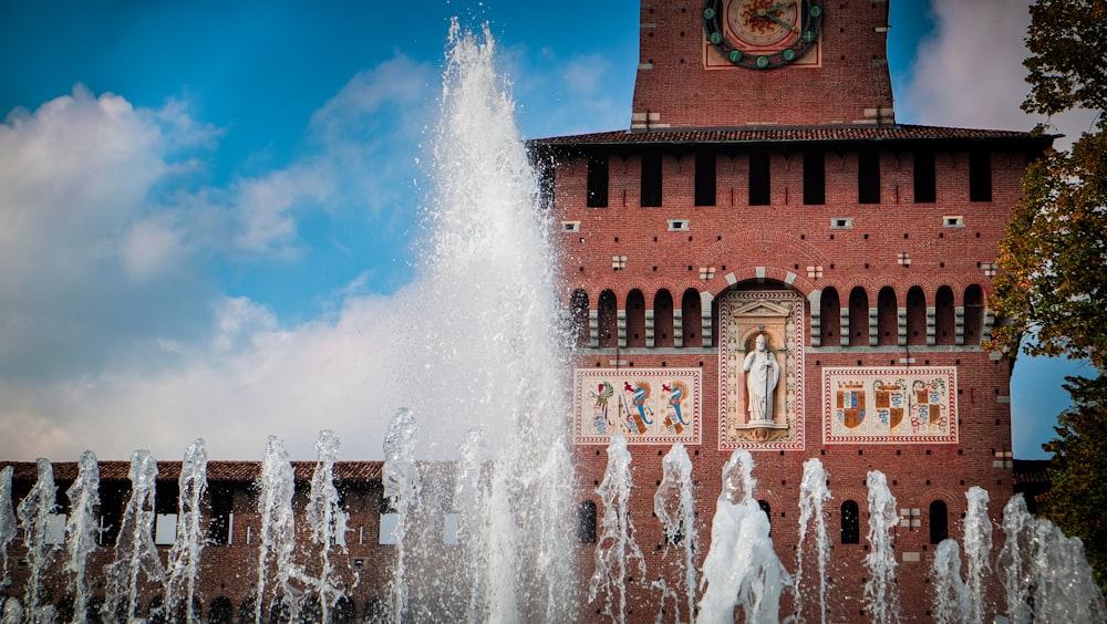 water fountain in front of brown building