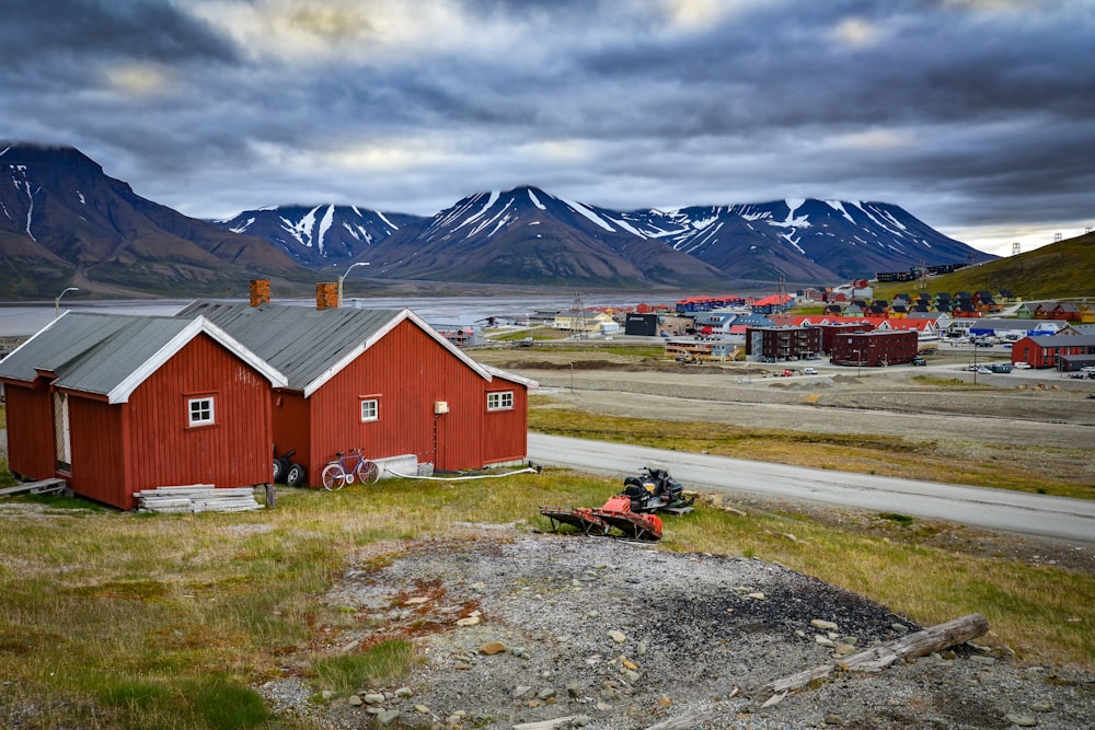 red and white barn near mountain under white clouds during daytime