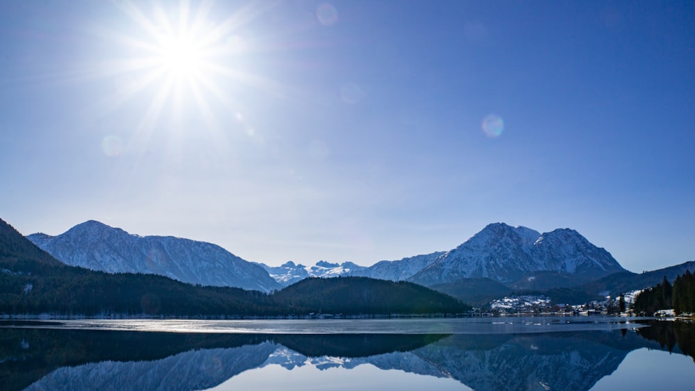 Specchio d'acqua vicino alla montagna sotto il cielo blu durante il giorno